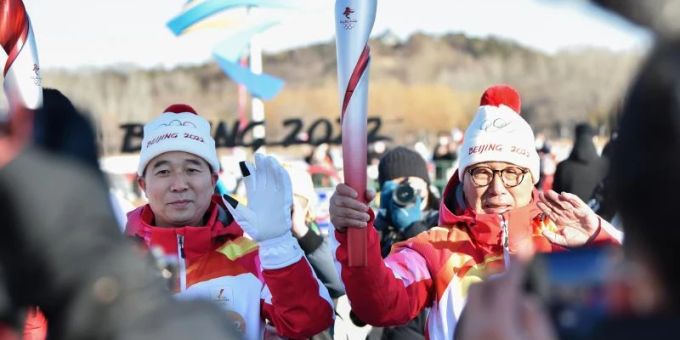 Der erste Fackelträger Luo Zhihan (r), ehemaliger Eisschnelllauf-Weltmeister, übergibt die Fackel an den chinesischen Astronauten Jing Haipeng. Foto: Chen Zhonghao/XinHua/dpa Der erste Fackelträger Luo Zhihan (r), ehemaliger Eisschnelllauf-Weltmeister, übergibt die Fackel an den chinesischen Astronauten Jing Haipeng. Foto: Chen Zhonghao/XinHua/dpa