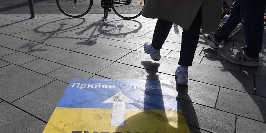 Ein Hinweisschild weist den ankommenden ukrainischen Flüchtlingen am Kölner Hauptbahnhof den Weg zur Erstversorgung. Foto: Roberto Pfeil/dpa