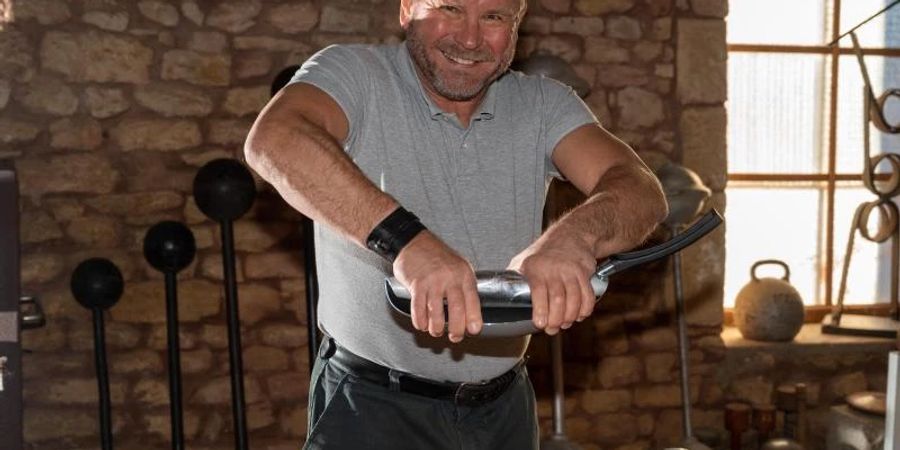 Georges Christen rollt mit blossen Händen in seiner Trainingsscheune eine handelsübliche Bratpfanne zusammen. Foto: Harald Tittel/dpa