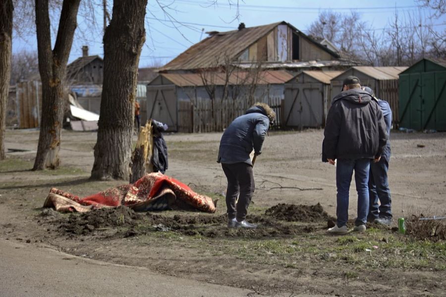 Ein Mann gräbt ein Grab für Verstorbene in Mariupol. Bisher wurden geschätzt 5000 Zivilisten getötet.