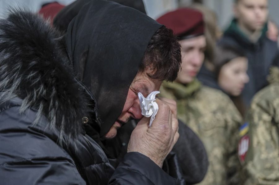 Eine ukrainische Frau weint bei der Beerdigung dreier Soldaten, die bei Gefechten in Cherson getötet wurden.