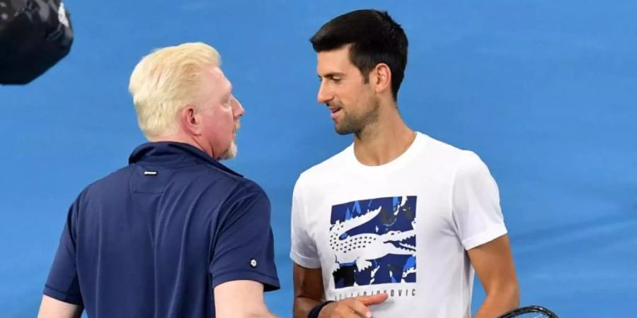 Boris Becker (l) spricht beim ATP Cup im Februar 2020 mit Novak Djokovic. Foto: Darren England/AAP/dpa