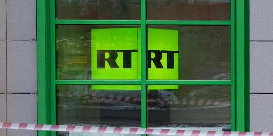 Das Logo des staatlichen russischen TV-Senders RT ist im Fenster des Firmenbüros zu sehen. Foto: Pavel Golovkin/AP/dpa