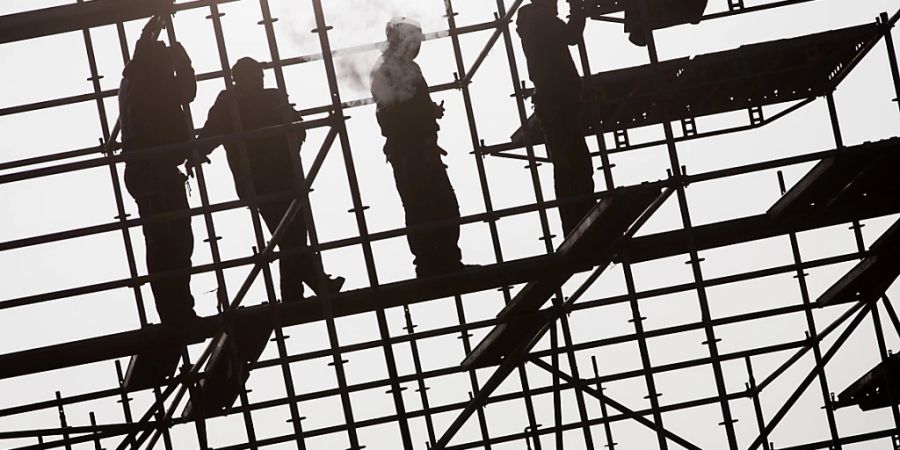 Arbeiter errichten in Hamburg auf einer Brückenbaustelle in der Hafencity ein Gerüst. (Archivbild)