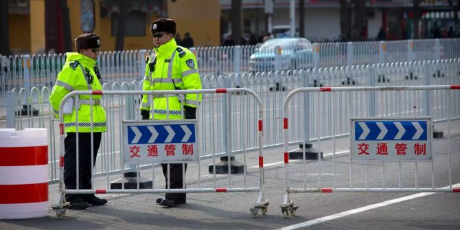 Chinesische Polizisten blockieren eine Strasse.