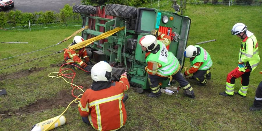 Feuerwehrleute beim Versuch den Karren wieder aufzustellen.