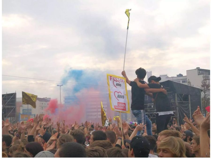 Bunte Farben wirbeln durch die Luft: Konzertbesucher heben die Hände und tanzen zur Musik.