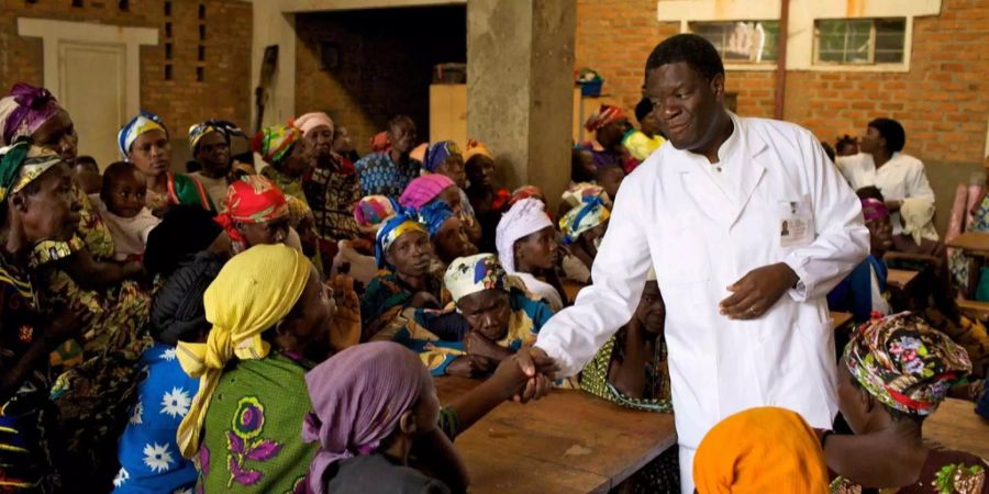 Arzt Dr. Denis Mukwege gibt einer Frau die Hand.