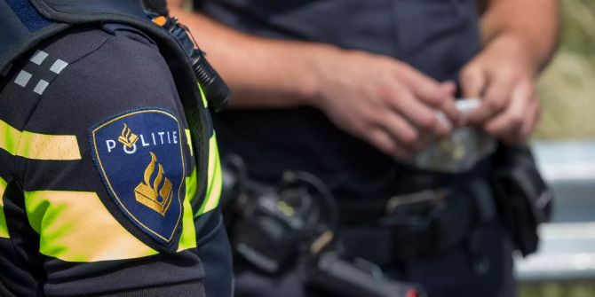 Ein Polizeibeamter aus den Niederlanden steht neben einem deutschen Kollegen.
