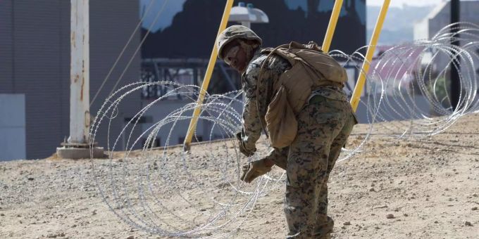 Ein US-Soldat verlegt Stacheldraht. Ein US-Soldat verlegt Stacheldraht.