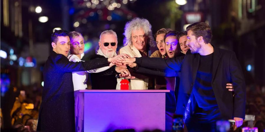 Roger Taylor und Brian May (M) mit Darstellern des «Bohemian Rhapsody»-Films Rami Malek (v.l.n.r), Lucy Boynton, Ben Hardy, Joe Mazzello, Allen Leech und Gwilym Lee bei der offiziellen Vorstellung einer Lichtinstallation zur Feier des Queen-Songs in der Carnaby Street in London (GB).