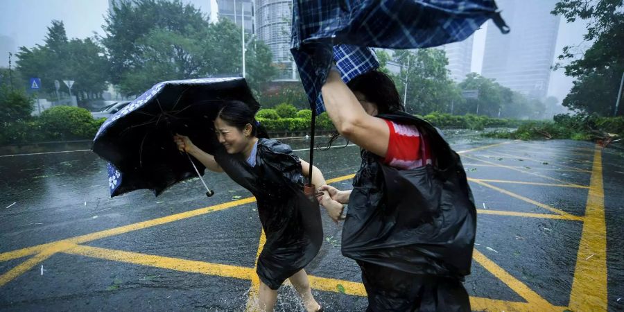 Zwei Bewohner von Shenzhen versuchen mit Regenschirmen gegen den starken Wind anzukämpfen.