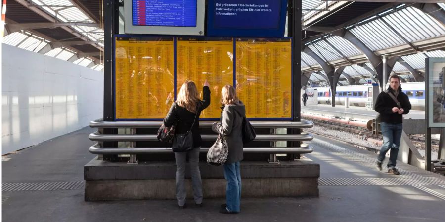 Zwei Reisende studieren am 11. Februar 2011 am Hauptbahnhof in Zürich den Fahrplan.