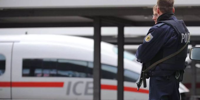 Das bayrische Landeskriminalamt untersucht die Manipulation einer ICE-Strecke, bei der ein Zug beschädigt worden ist. Zwei Polizisten stehen im Hauptbahnhof vor einem ICE.