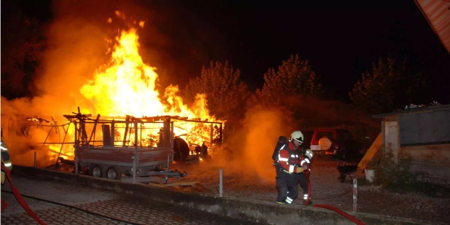 Feuerwehrleute in Gerlafingen SO versuchen den Brand eines Geräteunterstands zu löschen.