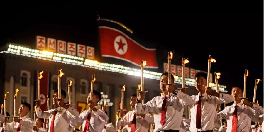 Nordkoreanische Jugendliche halten anlässlich eines Marschs zum 70. Jahrestag der Staatsgründung Nordkoreas Fackeln hoch.