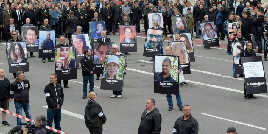 Rechte Demonstranten halten auf den Strassen von Chemnitz (D) Schilder mit Personen auf, die von Migranten getötet worden sind.