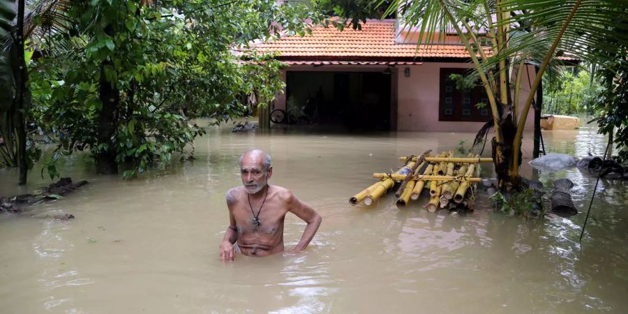 Ein älterer Mann watet durch die Fluten, um ein Rettungsboot zu erreichen. Der südindische Bundesstaat Kerala ist nach Regierungsangaben von der verheerendsten Flut der letzten 100 Jahre getroffen worden.