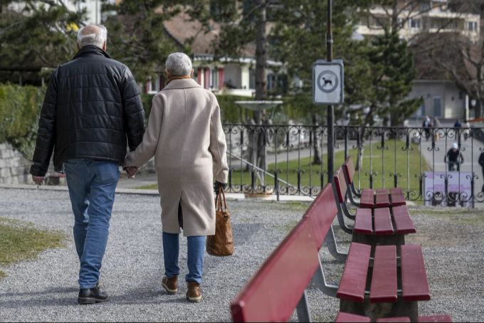 Ein älteres Paar spaziert in einem Park. (Symbolbild) Paar Spazierpark
