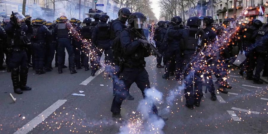 Polizisten werden während einer Demonstration gegen die geplante Rentenreform von Präsident Macron mit Wurfgeschossen beworfen. Foto: Michel Euler/AP/dpa