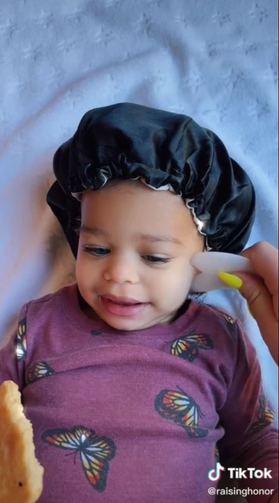 Diese Mama massiert das Gesicht ihres Babys mit einem Jade-Stein.