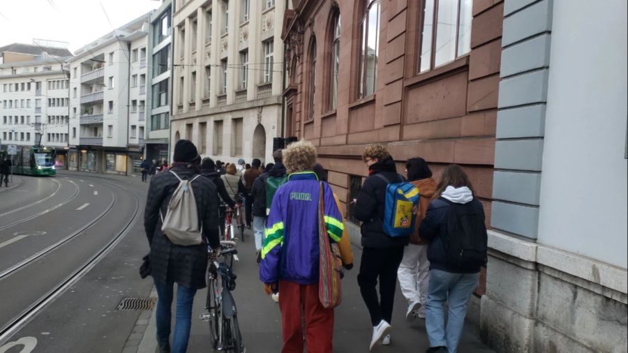 Mitglieder des Klimastreiks Schweiz laufen zum Gymnasium am Münsterplatz in Basel.