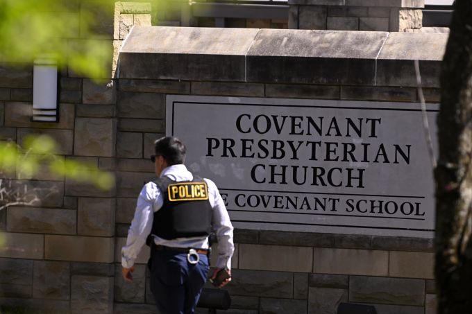 Ein Polizeibeamter geht nach einer Schießerei in Nashville, Tennessee, am Montag, 27. März 2023, an einem Eingang der Covenant School vorbei. Nashville School Shooting