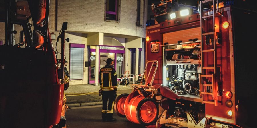 Ein Feuerwehrmann steht vor der Bankfiliale in Sandersdorf-Brehna.