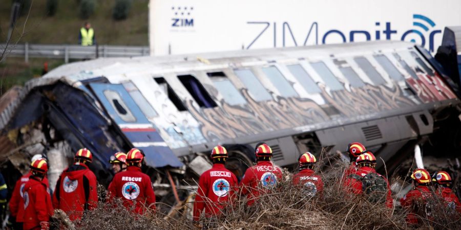 Rettungskräfte suchen in den Zugtrümmern nach Überlebenden.