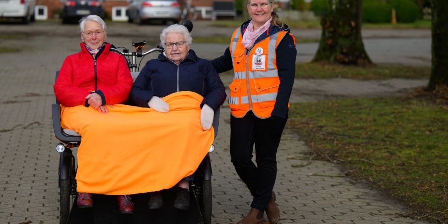 Ute Wischmann-Lübbers (r) steht neben der Rikscha mit Brigitte Görlich (l) und Elisabeth Lübbers.