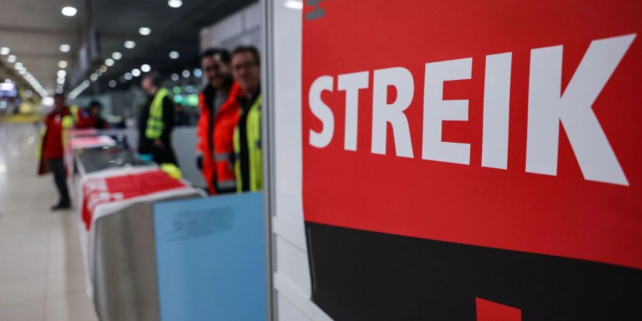 Ein Streikposten steht am Flughafen Köln/Bonn im Terminal.