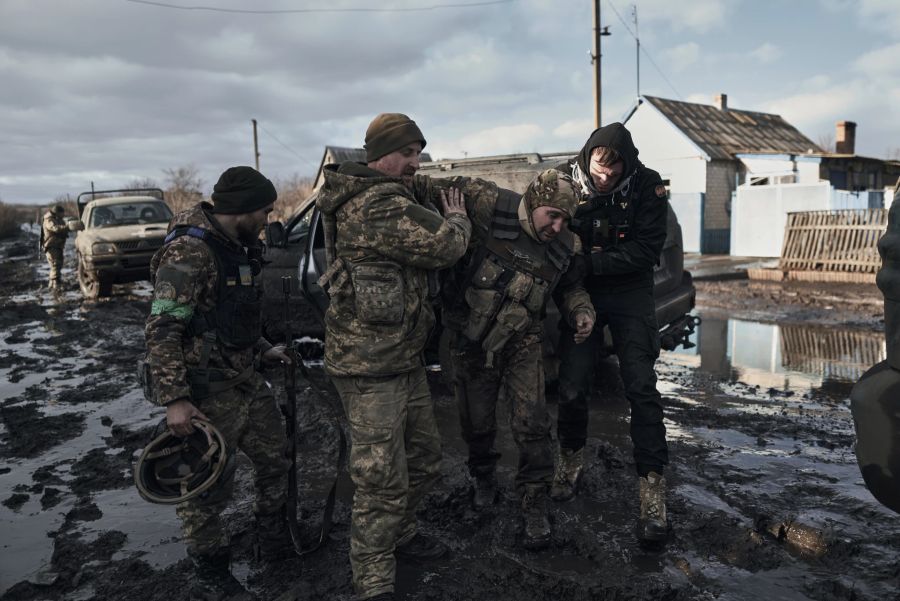 Ukrainische Soldaten helfen einem verwundeten Kameraden in ein Evakuierungsfahrzeug an der Frontlinie in Bachmut, Region Donezk, Ukraine, Montag, 20. Februar 2023.