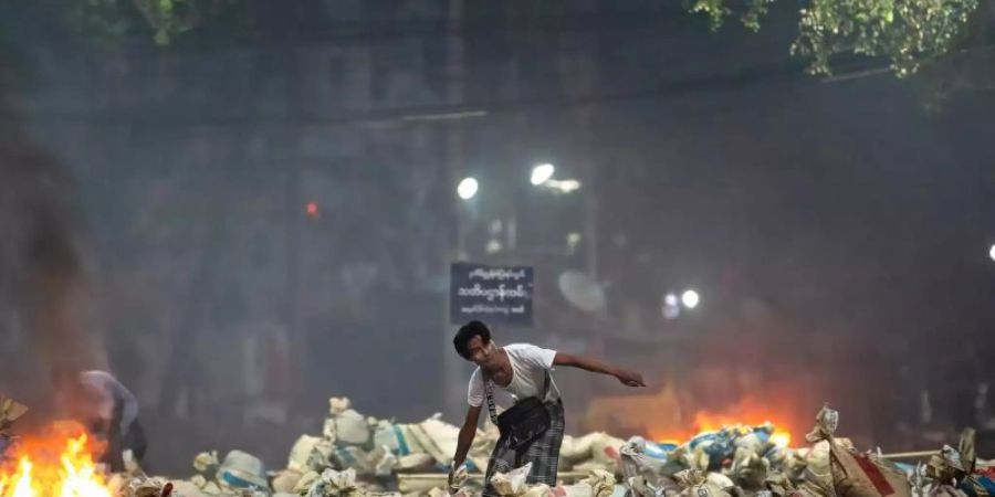 Ein Demonstrant stapelt Säcke auf einer Strasse als Barrikade während eines Protestes in Yangon. Foto: Theint Mon Soe/SOPA Images via ZUMA Wire/dpa