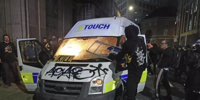 Demonstranten setzen einen Polizeiwagen vor der Bridewell Polizeiwache Brand. Der Protest richtet sich gegen ein neu verabschiedetes Polizeigesetz in Grossbritannien. Foto: Andrew Matthews/PA/dpa bristol