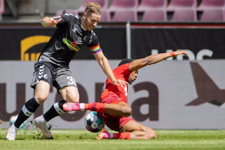 Freiburg-Captain Christian Günter (l.) kämpft mit Kölns Kingsley Ehizibue (r.) um den Ball.