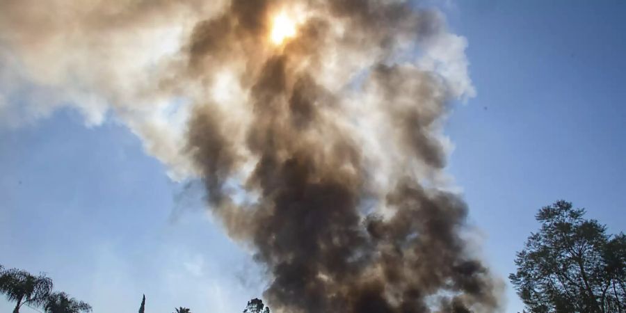 Rauch steigt nach einer grossen Explosion von Feuerwerkskörpern auf. Bei der grossen Explosion in Kalifornien sind mindestens zwei Menschen ums Leben gekommen. Foto: Watchara Phomicinda/The Orange County Register/AP/dpa - ACHTUNG: Nur zur redaktionellen Verwendung und nur mit vollständiger Nennung des vorstehenden Credits