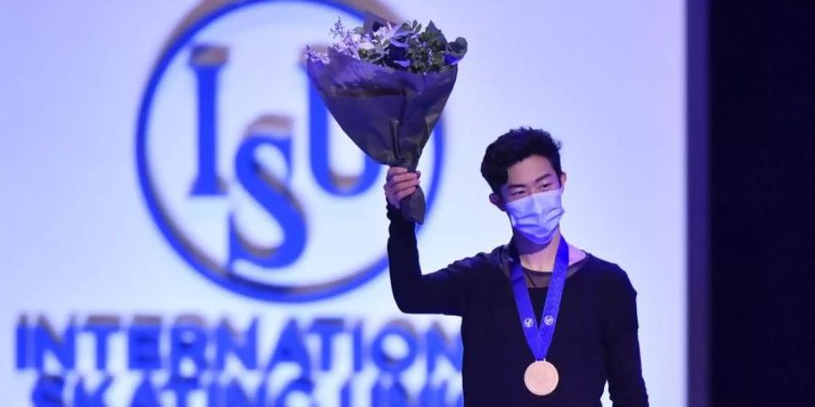 Der US-Amerikaner Nathan Chen steht nach Gewinn der Goldmedaille auf dem Podium und winkt. Foto: Martin Meissner/AP/dpa