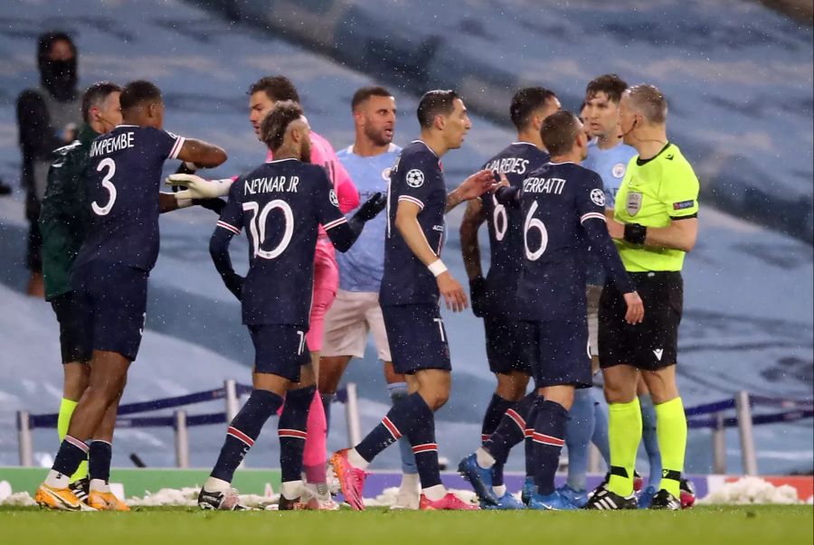 Angel Di Maria (11) von Paris Saint-Germain und seine Mannschaftskameraden umringen Schiedsrichter Bjorn Kuipers (r), nachdem er während des Halbfinal-Rückspiels in Manchester des Feldes verwiesen wurde.