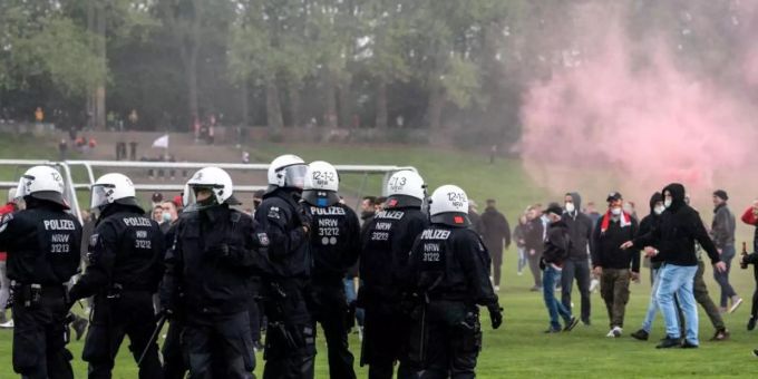Polizisten und Anhänger des 1. FC Köln stehen sich auf der Jahnwiese vor dem Stadion gegenüber. Foto: Marius Becker/dpa Polizisten und Anhänger des 1. FC Köln stehen sich auf der Jahnwiese vor dem Stadion gegenüber. Foto: Marius Becker/dpa