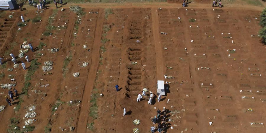 Friedhofsarbeiter tragen auf dem Friedhof Vila Formosa in Sao Paulo einen Sarg. Foto: Andre Penner/AP/dpa