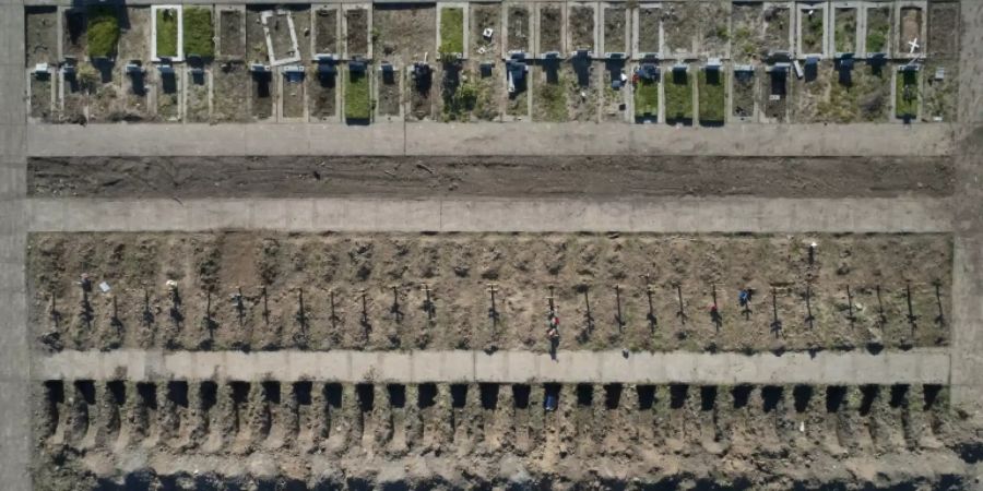 Frisch ausgehobene Gräber auf einem Friedhof in Buenos Aires