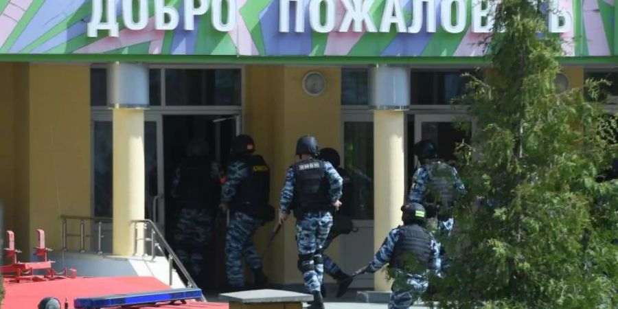 Rettungswagen und Polizeifahrzeuge mit Blaulicht und Sirene: der Tatort in der russischen Stadt Kasan nach dem tödlichen Angriff. Foto: Maksim Bogodvid/Sputnik/dpa