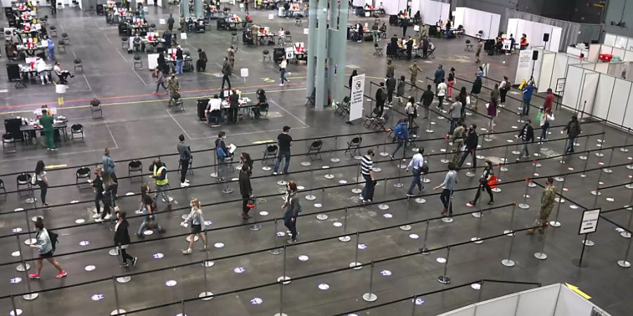 Menschen warten im Jacob K. Javits Convention Center in New York auf ihre Corona-Impfung. Foto: Timothy A. Clary/Pool AFP/AP/dpa