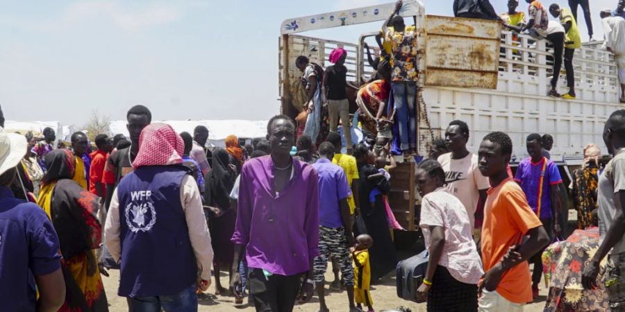 Menschen, die aus dem Sudan geflohen sind, steigen von der Ladefläche eines Lastwagens im Flüchtlingslager Renk. Foto: Peter Louis/World Food Programme/dpa