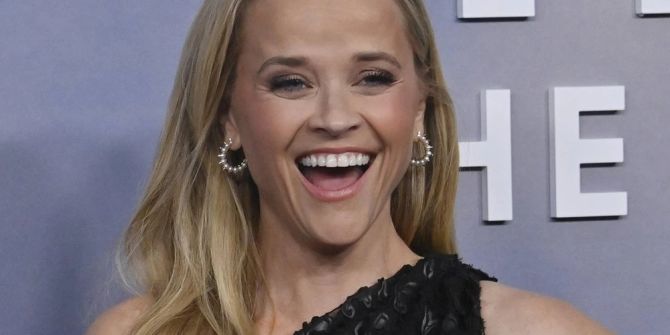 Reese Witherspoon strahlt auf dem roten Teppich.