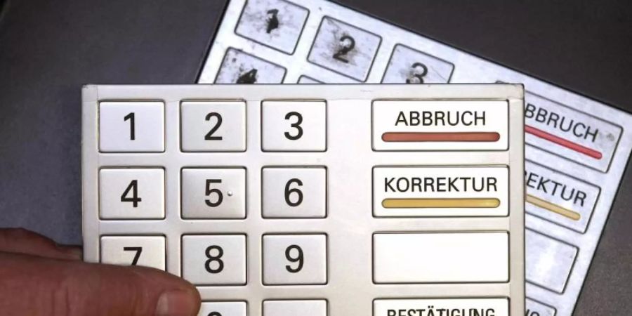 Auf einem Modell-Bankautomaten wird ein täuschend echt aussehendes zweites Tastenfeld angebracht. Foto: Fredrik von Erichsen/dpa