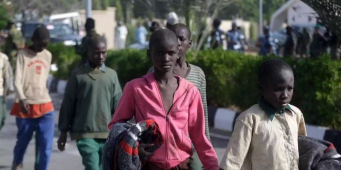 Nigerianische Militärmitglieder und Beamte eskortieren wieder freigelassene Schüler, die Anfang der Woche aus der Schule «Government Science Secondary School» in Kankara in der Nordregion Katsina von Extremisten entführt worden waren. Foto: Sunday Alamba/AP/dpa nigeria