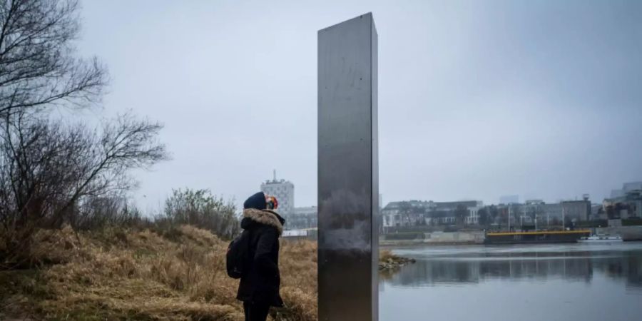 Eine Frau vor der  Metallsäule in Polen