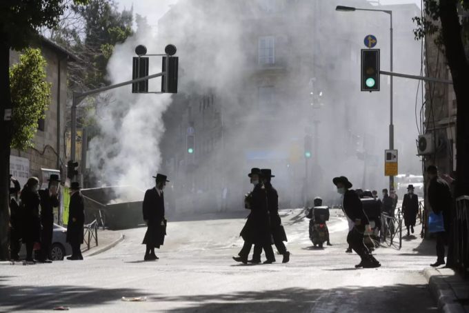 Orthodoxe Juden vor einem brennenden Müllcontainer am Rande der Ausschreitungen. Coronavirus Israel Ultraorthodoxe