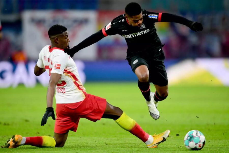 RB-Verteidiger Nordi Mukiele (l.) grätscht gegen Leverkusen-Flügel Leon Bailey (r.).